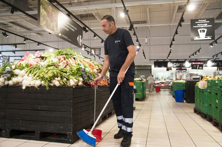 Employé du groupe SIFU balayant pendant le service de nettoyage dans un supermarché