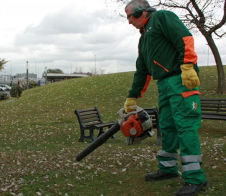 Un jardinier du groupe Sifu nettoie un espace vert avec un souffleur