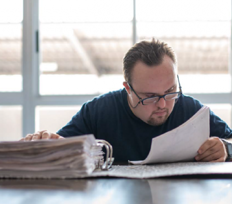 Homme handicapé lisant la documentation dans un bureau