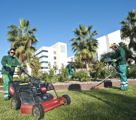 Deux jardiniers du Grupo SIFU tondre l'herbe dans un espace vert