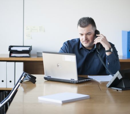 Un employé du Groupe SIFU travaillant avec un ordinateur portable et passant un appel