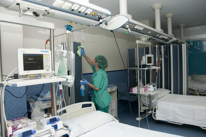 Un employé du Groupe SIFU nettoyant une chambre d'hôpital