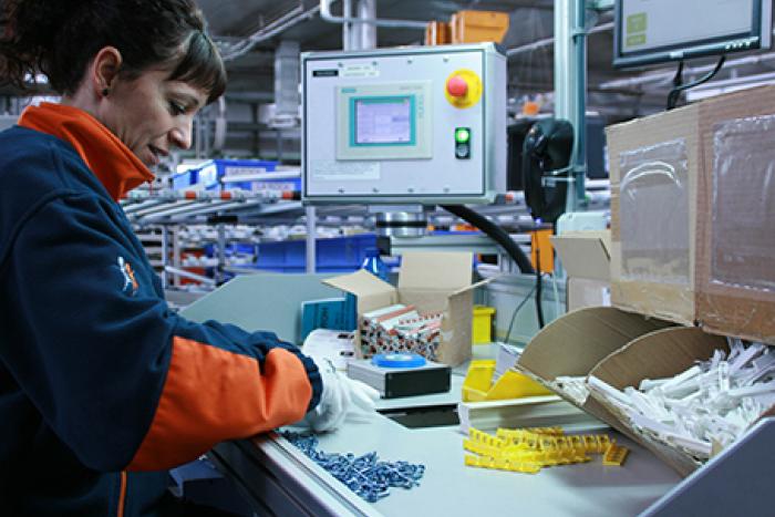 Employé du groupe SIFU à une table d'assemblage industriel