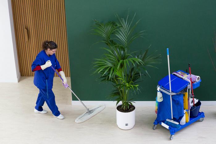 Employé du Groupe SIFU nettoyant le sol d'un bureau